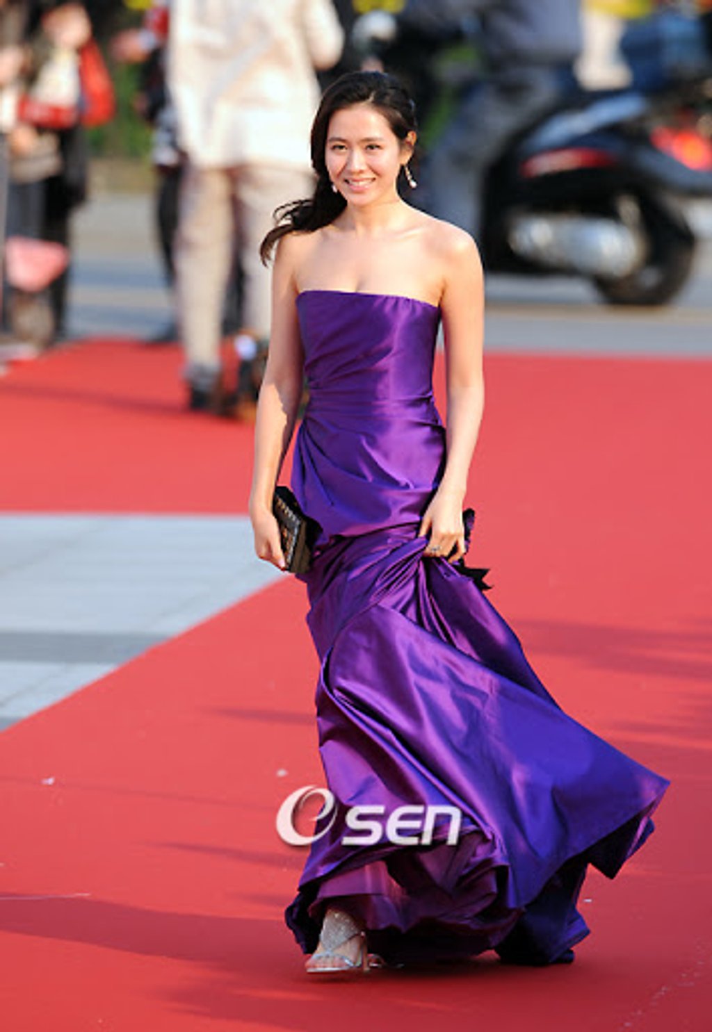 Năm 2008, chiếc đầm tím sắc nét đã mang đến cho nữ diễn viên diện mạo vô cùng sang trọng. Lựa chọn này cũng tôn lên được rất nhiều điểm mạnh của Son Ye Jin như làn da trắng ngần, vòng ngực đầy đặn hay bờ vai nuột nà.
