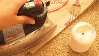 Cách tẩy sáp đèn cầy dính trên thảm bằng bàn ủi