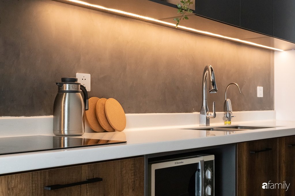 Góc bếp ấm cúng và hiện đại khi có sự liên kết màu sắc với phòng khách từ gỗ đến bức tường bếp.