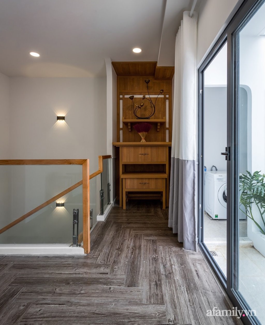 Cầu thang gỗ với lan can kính mang ánh sáng và sự thông thoáng vào nhà.
