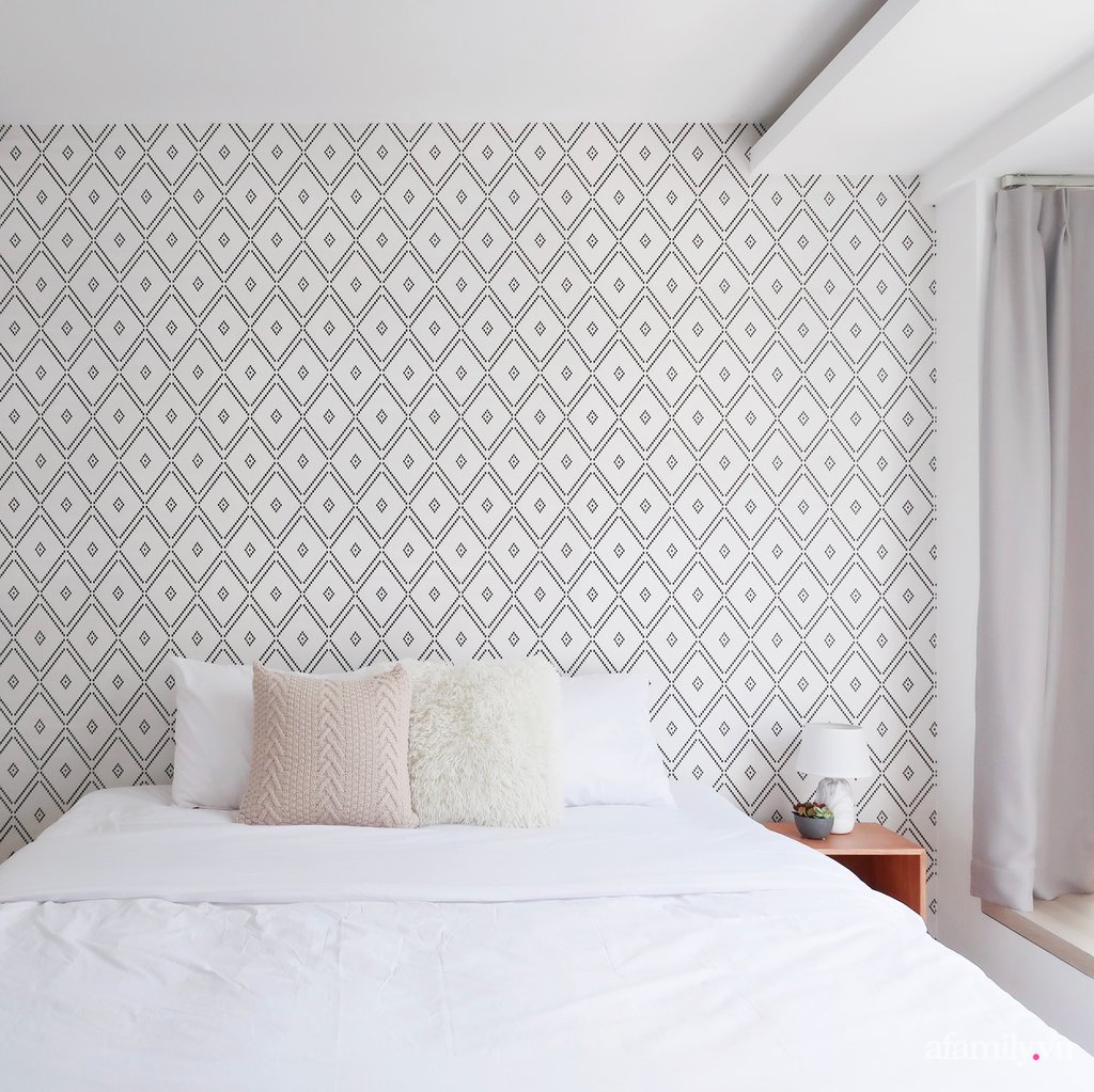 Phòng ngủ với tông màu trắng cơ bản. Những chiếc gối bông êm ái và giấy dán tường hoa văn được sử dụng làm điểm nhấn cho không gian.