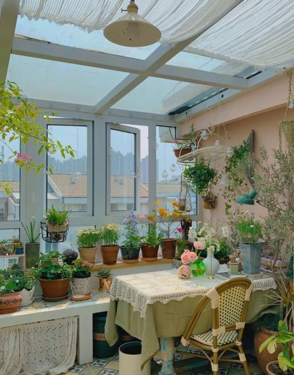Một phần sân thượng được làm nhà kính đủ ánh sáng để trồng cây và sum họp gia đình.